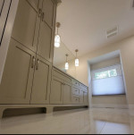 bathroom with ample storage, counter-to-ceiling mirror, and twin pendant lighting