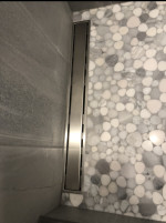 bathroom shower with pebble floor tiling