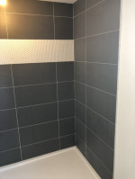 bathroom shower with large dark tiles