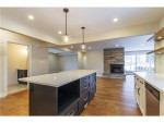 kitchen with wood flooring, center island, fireplace in familyroom