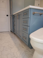 bathroom with blue cabinetry and hexagonal floor tiles
