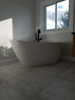 bathroom with deep stand-alone tub and black faucet