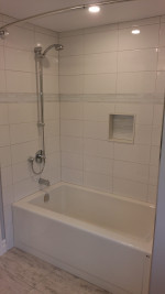 bathroom with deep tub and show, with large tiles, and pot lights