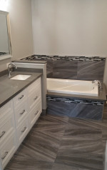 bathroom with drop-in tub and marble tiles