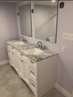 bathroom with dual vanity mirrors and marble countertop