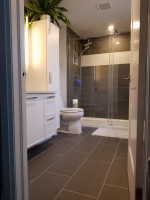 bathroom with large floor tiles and shower with glass doors
