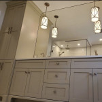 bathroom with ample storage, counter-to-ceiling mirror, and twin pendant lighting