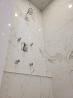 bathroom shower with large marble tiles and chrome fixtures