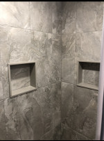 bathroom shower with large marble tiles and recessed soap holder
