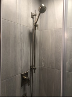 bathroom shower with marble tiles and height-adjustable shower-head