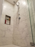 bathroom shower with marble tiles and glass doors