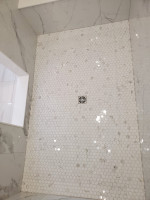 bathroom shower with hexagonal tiles and center drain