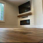 in-wall fireplace with white paneling and wood mantle and TV