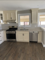 kitchen with wood flooring, cream-colored cabinets, and pot lighting