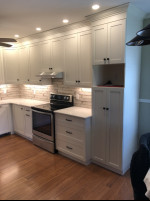 kitchen with white cabinets, wood flooring, and pot lighting