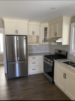 kitchen with white cabinets, wood flooring, and stainless steel appliances