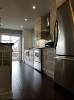 kitchen with dark wood flooring and pot lights, stainless steel appliances