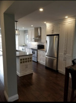 kitchen with dark wood flooring, pot lights, and pillar