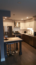 kitchen with pot lights, white cabinets, and wood flooring