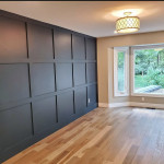 dark paneled family room with wood flooring and bay window