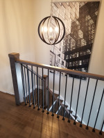 residential stairway with dark wood and spherical chandelier