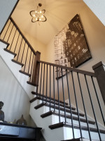 residential white stairway with dark wood and spherical chandelier